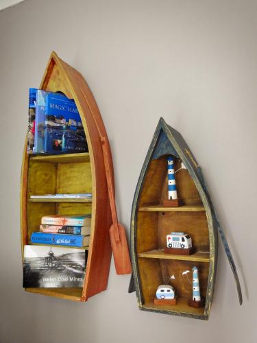 a book shelf with a toy train in a mirror at Butland House in Pembrokeshire