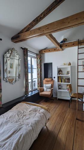 een slaapkamer met een bed en een stoel in een kamer bij Chambre privée centre de Paris proche Marais in Parijs