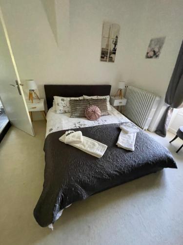a bedroom with a large bed with two towels on it at Vue du Château d'Excideuil en chambres in Excideuil