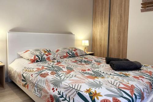 een slaapkamer met een bed met een kleurrijk dekbed bij Appartement calme, climatisé 3min à pied de la mer in Palavas-les-Flots