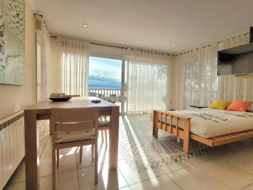 a bedroom with a bed and a desk and a window at La Marina in Lloret de Mar