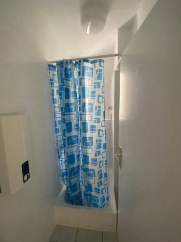 a bathroom with a blue shower curtain in a room at Chic & Trendy Mainz Apartment near cetral station in Mainz