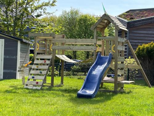 einen Holzspielplatz mit Rutsche und Leiter in der Unterkunft Seaside Amrum 17 in Norddorf