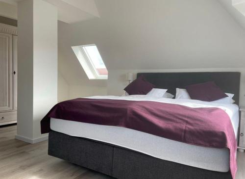 ein Schlafzimmer mit einem großen Bett mit lila Bettwäsche in der Unterkunft Seaside Amrum 17 in Norddorf