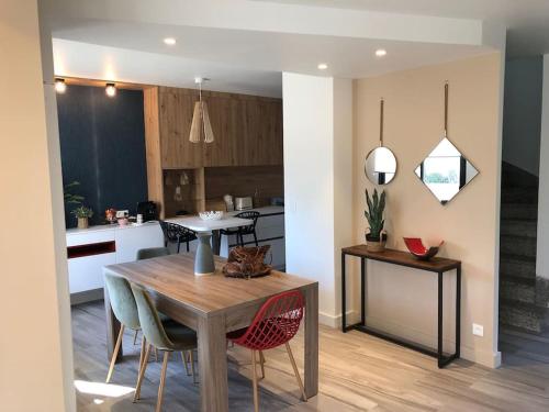 une cuisine et une salle à manger avec une table et des chaises dans l'établissement Maison de famille rénovée - Larmor centre bourg, à Larmor-Plage