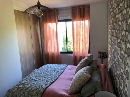 - une chambre avec un lit doté d'oreillers et d'une fenêtre dans l'établissement Maison de famille rénovée - Larmor centre bourg, à Larmor-Plage