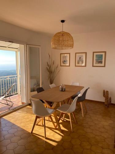 une salle à manger avec une table et des chaises en bois dans l'établissement Villa tout confort, vue mer exceptionnelle, à Cervione, à Cervione