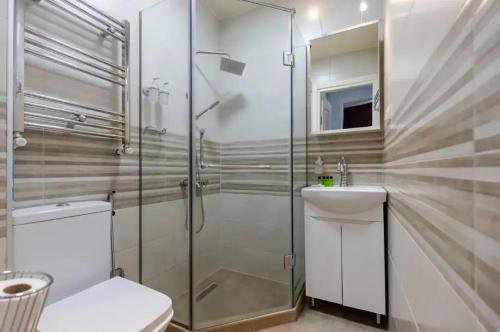 e bagno con doccia, servizi igienici e lavandino. di bubukin a Batumi
