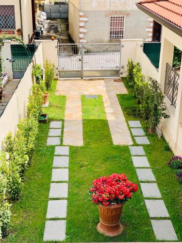 a garden with red flowers in a yard at CB House Tuscany in Pietrasanta