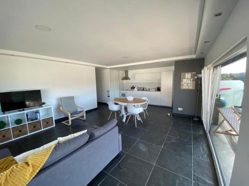 a living room with a couch and a table at Zambujeiraseahouse - 100m da praia in Zambujeira do Mar