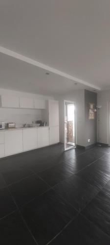 an empty room with an open door and a room with black floor at Zambujeiraseahouse - 100m da praia in Zambujeira do Mar