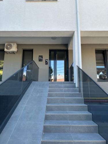 a staircase leading up to a building with glass doors at Stadium Central Apartment Residence & terrace in Craiova