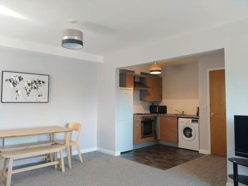 a kitchen with a table and a dining room at Parkside Apartment Normanton in Wakefield