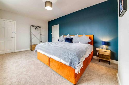 a bedroom with a large bed and a blue wall at The Collier's Rest: 3 bed home in South Yorks with parking & garden. in Barnsley