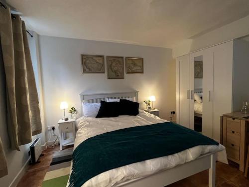 Exclusive flat in Oxford Centre في أوكسفورد: غرفة نوم بسرير كبير مع بطانية خضراء