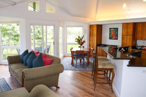 uma sala de estar com um sofá e uma mesa em Walk to Beach&Sunset - Luxury Villa on the Princeville Golf Course em Princeville