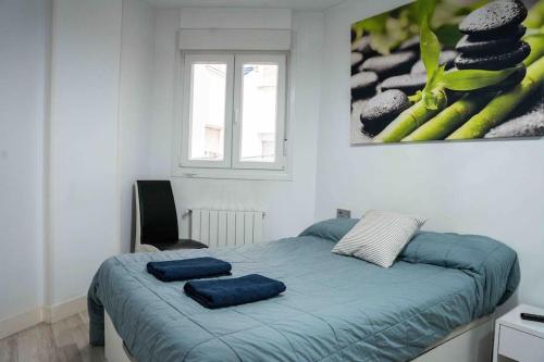 een slaapkamer met een bed met twee blauwe handdoeken erop bij La bona vida Vitoria in Arriaga