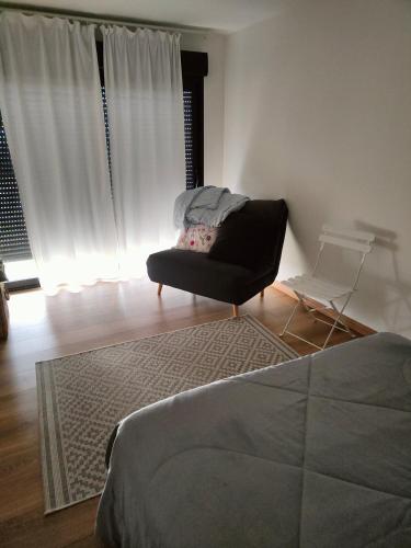 een woonkamer met een bank en een stoel bij Maryse in Douvrin