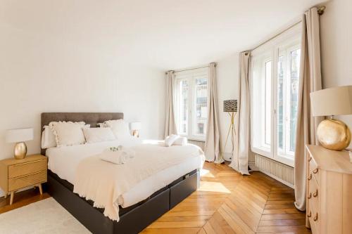 - une chambre blanche avec un grand lit et des fenêtres dans l'établissement 8P - 3BR Le Marais Spacious - Central - Historic Apt, à Paris