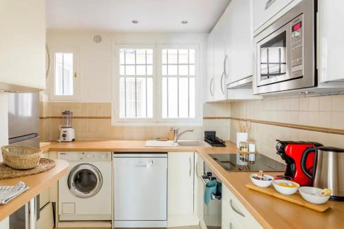 une cuisine avec une machine à laver et un évier dans l'établissement 8P - 3BR Le Marais Spacious - Central - Historic Apt, à Paris