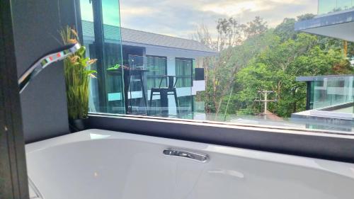 a bathroom with a window with a bath tub and a sink at B507-top Floor Pool View 1 Br At Ao Nang Beach in Ao Nang Beach