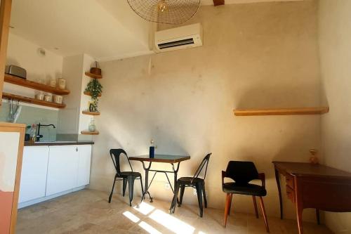 a kitchen with a table and chairs in a room at la Perle Rare - Centre-Ville in Sète