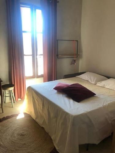 une chambre avec un grand lit blanc avec une fenêtre dans l'établissement la Perle Rare - Centre-Ville, à Sète