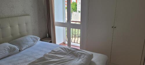 a bedroom with a bed and a door to a balcony at Comfy room near Metro in Lisbon