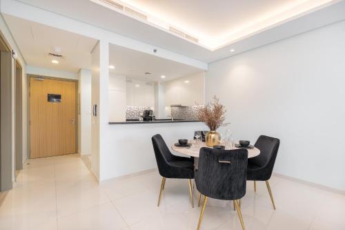 a dining room with a table and black chairs at Stylish 2Bedroom w infinity pool on the 64th floor in Dubai