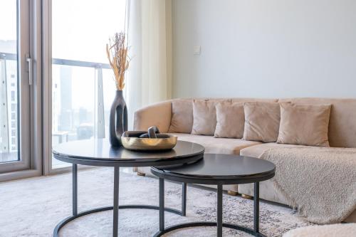 a living room with a couch and a table with a vase at Stylish 2Bedroom w infinity pool on the 64th floor in Dubai