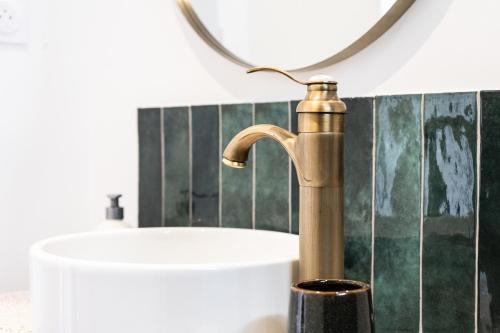 La salle de bains est pourvue d'un robinet en laiton et d'un lavabo. dans l'établissement Le grand Arth&M Clermont Ferrand, à Clermont-Ferrand