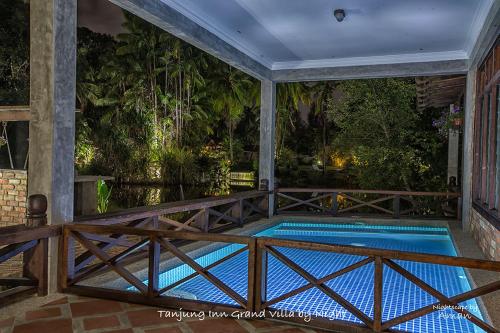 a swimming pool on a porch with a wooden fence at Tanjung Inn in Kuantan