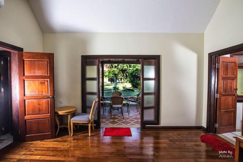 a living room with a table and chairs and a door at Tanjung Inn in Kuantan
