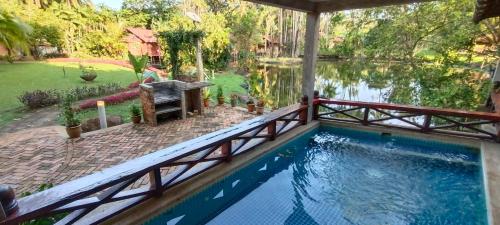 a swimming pool with a bridge over a lake at Tanjung Inn in Kuantan