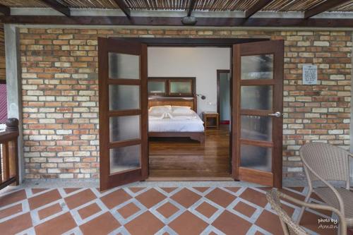 a bedroom with a bed in a brick wall at Tanjung Inn in Kuantan