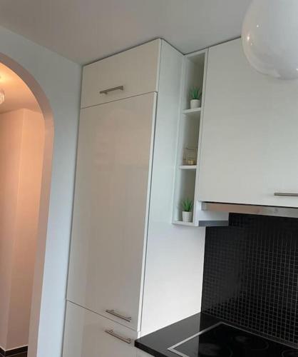 a kitchen with a white cabinet with plants on it at Airport City Zürich in Opfikon