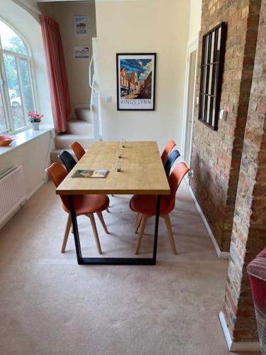 a dining room with a wooden table and chairs at Centre of town House 3 Bedrooms Sleeps 5 and Infant Free Onsite Parking 2 Cars in King's Lynn