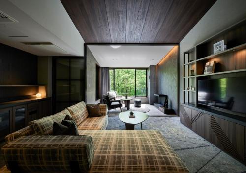 a living room with a couch and a tv at Fufu Kyu-Karuizawa Seiyou No Mori in Karuizawa