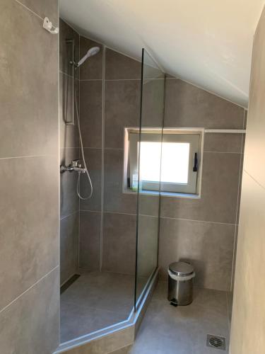 a bathroom with a shower with a glass door at studio Palerostravel in Paleros
