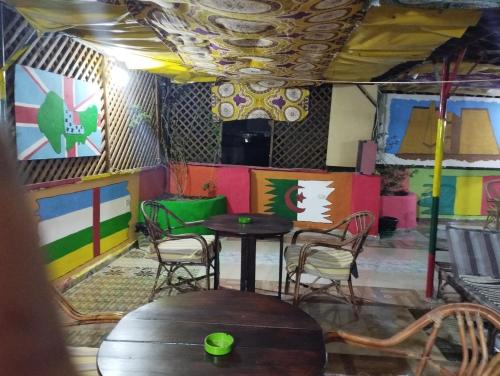 Bob Marley Peace hostels luxor في الأقصر: طاولة وكراسي في غرفة مع جدران ملونة