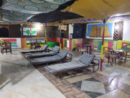 Bob Marley Peace hostels luxor في الأقصر: غرفة بها مجموعة من الكراسي والطاولات