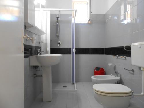 bagno bianco con servizi igienici e lavandino di Casa Raffaele a Leuca