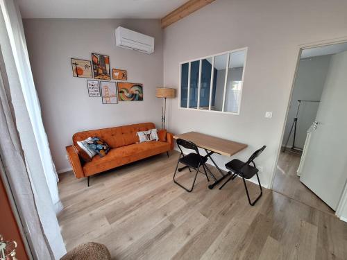 uma sala de estar com um sofá e uma mesa em Bienvenue chez toi - TV, WiFi em Castanet-Tolosan