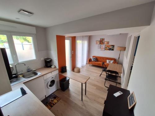 Bienvenue chez toi - TV, WiFi في Castanet-Tolosan: مطبخ وغرفة معيشة مع أريكة وطاولة
