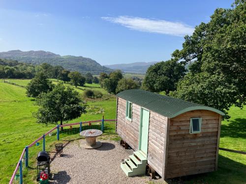 une petite maison dans un champ avec foyer extérieur dans l'établissement Shepherds hut above mawddach estuary, à Dolgellau