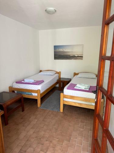 a room with two beds and a table at Apartments Suzana in Herceg-Novi