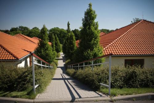 a walkway between two houses with red roofs at Golf Hotel Austerlitz in Slavkov u Brna