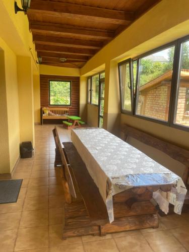 a large wooden bed in a room with windows at House by the river in Polyana