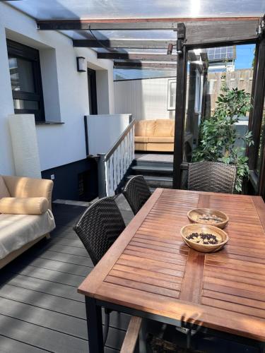 a wooden table and chairs on a balcony at FeWo by HD mit Parkplatz, Wallbox, Wintergarten in Bad Salzuflen