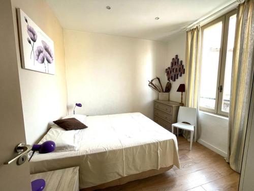 a bedroom with a bed and a dresser and a window at Lou pescadou in Saint-Raphaël